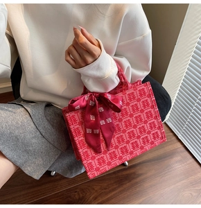 Detail view of red bridal tote bag with traditional Xi character pattern and bow ribbon