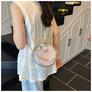 Detail of round crossbody bag with pink woven texture and pearl chain strap decoration