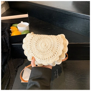 Detail of cream crochet shoulder bag with scalloped edges and brown leather strap