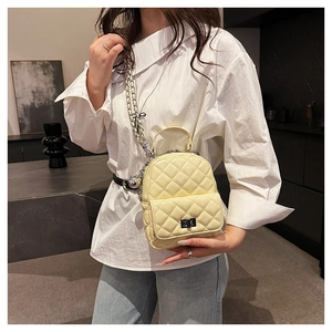 Quilted mini backpack in light yellow leather featuring chain strap and metal lock