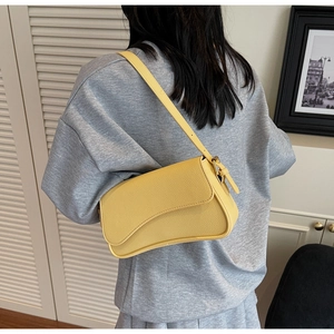 Close-up of bright yellow litchi pattern shoulder bag with adjustable leather strap