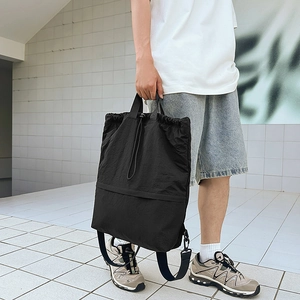 Outdoor-Streetview eines vielseitigen schwarzen Nylon-Kordelzug-Rucksacks an einem Modell