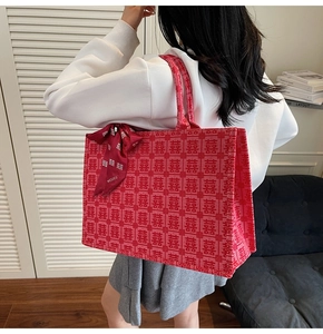 Detail view of red bridal tote bag with traditional Xi jacquard patterns and ribbon bow
