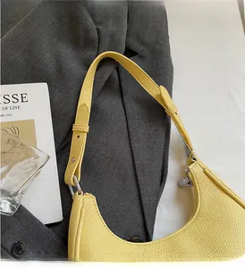 Detailed view of yellow lychee grain leather hobo bag with adjustable shoulder strap