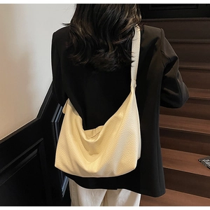 Detailed view of cream white minimalist crossbody bag with soft litchi texture and wide strap