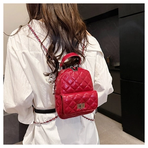 Macro view of red quilted leather backpack with silver chain straps and turn-lock