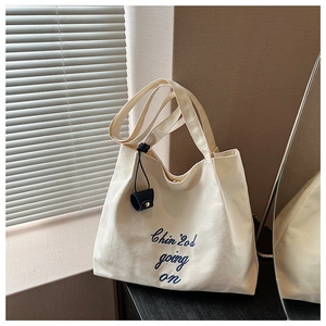 Détail du sac cabas en toile avec broderie bleu marine et fermoir magnétique doré