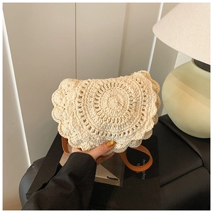 Close-up of beige woven round shoulder bag featuring scalloped edges and slim leather strap