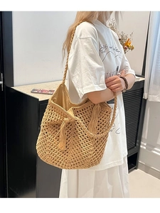 Handwoven straw tote bag with hollow knit design and tassels for beach summer holidays
