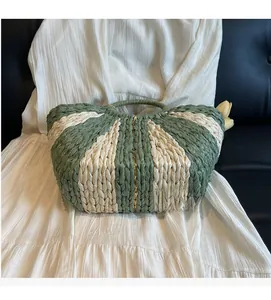 Detail shot of green and white woven straw bag showing the intricate handmade texture
