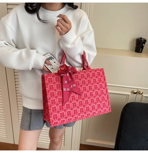 Detail of red wedding tote bag with Xi character patterns and a decorative bow