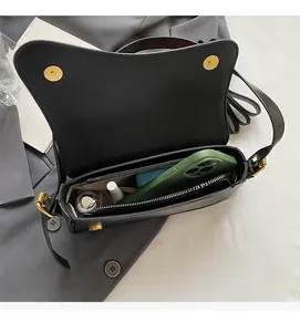 Vue intérieure du sac selle noir montrant l'espace pour téléphone et cosmétiques
