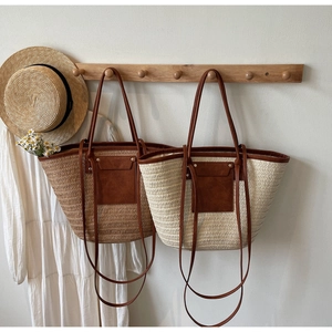 Detail of straw woven tote bags with leather straps and front pockets in summer style