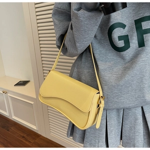 Detail of yellow lychee pattern leather shoulder bag with wave flap design