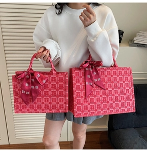 Detail showing two sizes of red wedding tote bags with traditional Xi jacquard patterns