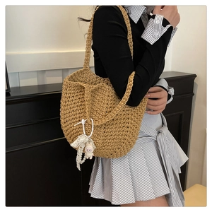 Detail of hand-woven khaki shoulder bag with cute rabbit doll and textured crochet pattern