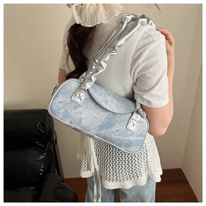 Dettaglio della borsa a spalla in denim lavato azzurro con tracolla plissettata argento retrò
