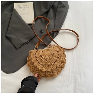 Detail of bohemian woven saddle bag showing textured scallop pattern and leather strap