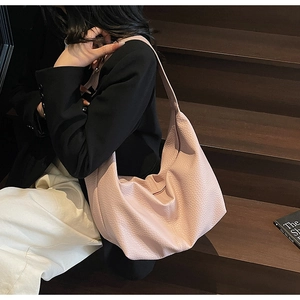 Detail of pink lychee leather crossbody bag with pleated texture and wide strap