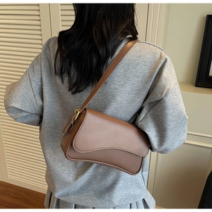 Détail du sac sous le bras marron caramel avec rabat asymétrique et boucle dorée