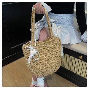 Detailed weave pattern on a beige woven tote bag with a cute white rabbit charm
