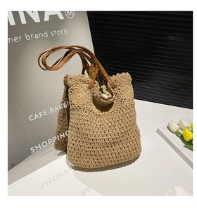 Detail of beige hand-woven tote bag showing crochet texture and brown leather straps