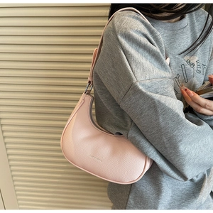 Detail of pink hobo bag with pebble leather texture and silver zipper on model