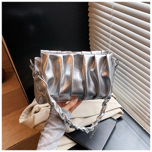 Detail of silver metallic pleated handbag featuring a textured braided shoulder strap
