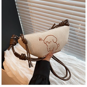 Détail de la broderie chiot et de la bandoulière en corde nouée sur le sac en toile beige