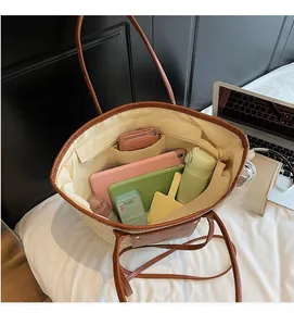 Top-down view of a spacious straw tote bag interior with durable brown leather straps