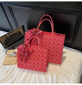 Close-up of red Chinese wedding tote set with Xi character patterns and decorative silk scarf