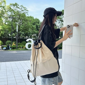 Detailansicht der beigen Nylon-Kordelzugtasche mit verstellbarem schwarzem Schultergurt
