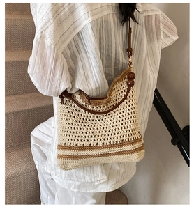 Detailed view of woven tote bag with leather straps and decorative wooden beads