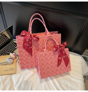 Close-up of pink wedding tote bags featuring red Xi characters and silk ribbon bows
