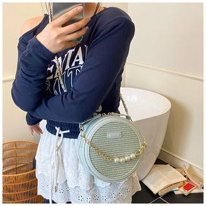 Mirror selfie showing mint green round crossbody bag with pearls and chain strap