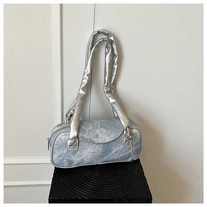 Dettaglio della trama in denim marmorizzato e dei manici metallici argentati della borsa