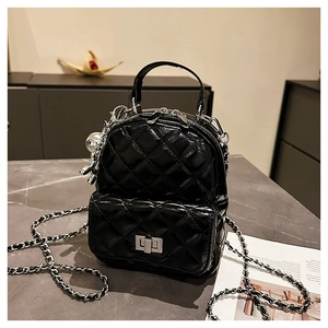 Macro view of black quilted patent leather backpack with silver chain and metal clasp