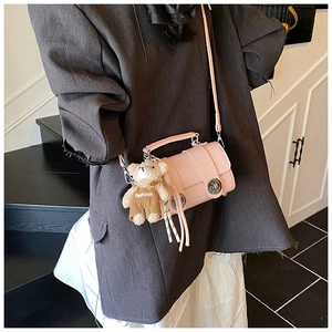 Pink crossbody handbag with metal buckle and a cute brown teddy bear plush charm
