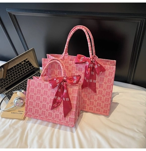 Detail of two pink tote bags with traditional Xi pattern and velvet ribbon bows