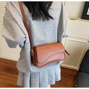 Sac bandoulière en cuir marron avec rabat asymétrique et boucle en métal doré chic