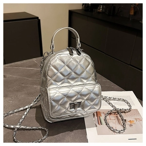 Close-up of metallic silver quilted mini backpack with metal twist-lock and chain strap
