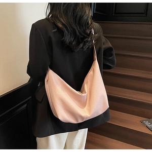 Pink lychee grain leather tote bag shown on shoulder with wide strap detail