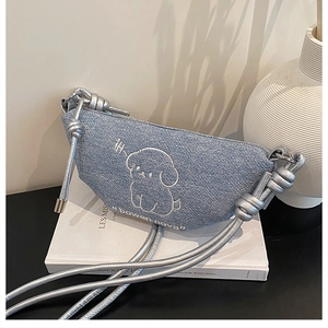 Détail du sac demi-lune en denim bleu avec broderie chien et bandoulière en corde