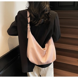 Detailed shot of pink lychee leather hobo bag with adjustable wide strap on model