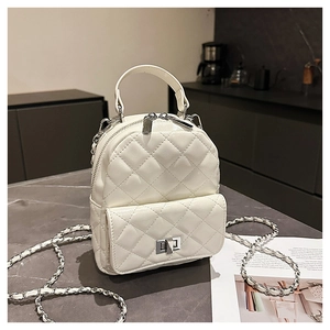 Close-up of white quilted mini backpack with silver metal zipper and chain strap detail