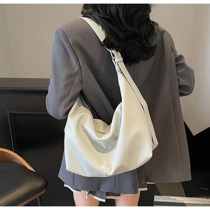 Detailed view of white lychee leather texture on a minimalist hobo shoulder bag for women