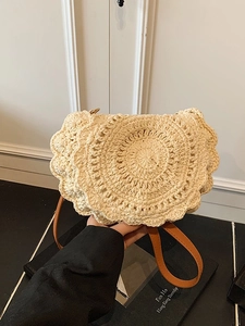 Minimalist woven straw saddle bag with round crochet pattern and brown leather strap