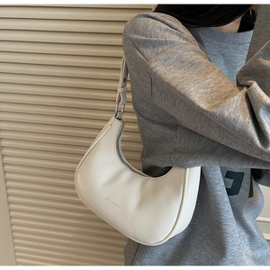 Detail of white half-moon bag featuring premium lychee texture and silver zipper