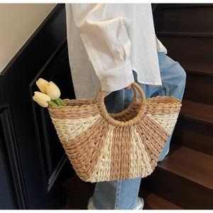 Close-up of contrast woven straw bag with radial patterns and integrated round handle