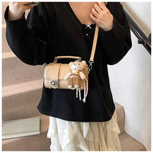 Chic beige glossy crossbody bag with round metal lock and cute teddy bear pendant